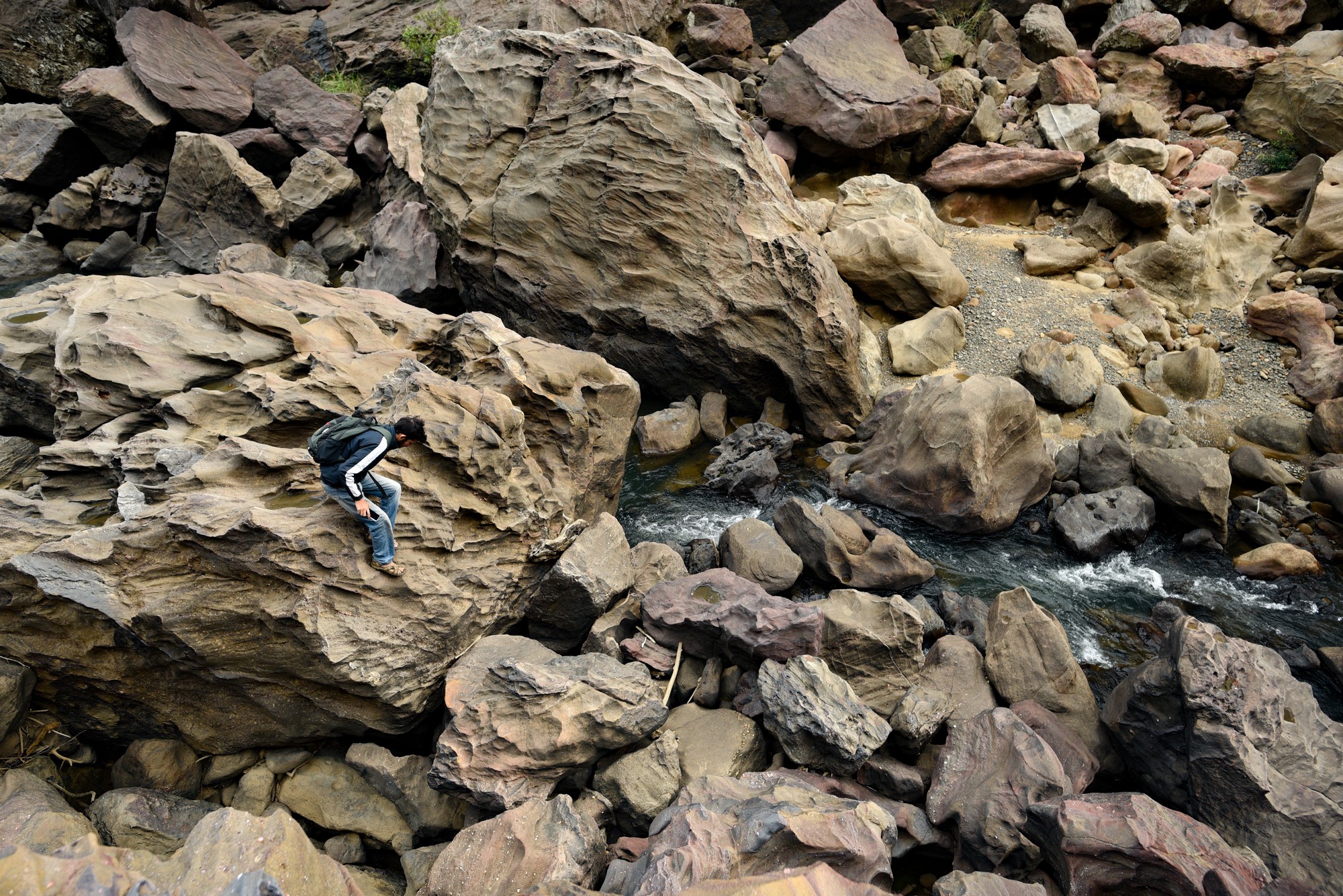 The Satpura Otter Saga - Many remote hill streams of the Satpura Tiger Reserve are marked by gigantic boulders strewn haphazardly with clear water gurgling through them. A team member navigating through them provides a scale to gauge the size of these boulders. Photo: Aditya Joshi/WCT